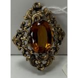 A citrine and yellow metal mounted brooch with scrolling border 6.5 cm long x 5.