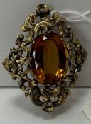 A citrine and yellow metal mounted brooch with scrolling border 6.5 cm long x 5.