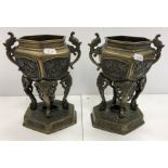 A pair of Chinese bronze urns or censers of hexagonal form with relief work decoration of exotic