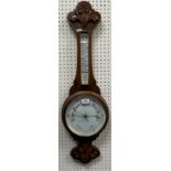 A late Victorian carved oak cased aneroid barometer with mercury thermometer,