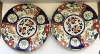 A pair of 19th Century Japanese Imari chargers of typical form with panel decoration of garden