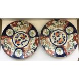 A pair of 19th Century Japanese Imari chargers of typical form with panel decoration of garden