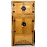 A Chinese elm cupboard or wardrobe in two sections,