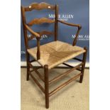 An Arts and Crafts ash framed ladder back rush seat elbow chair in the manner of William Morris,