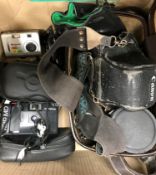 A box of various cameras including a Canon AV-1 and various accessories,