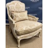 A modern buttoned upholstered armchair in the Victorian manner on turned front legs to brass