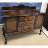 An early 20th Century mahogany serpentine fronted sideboard with three central drawers flanked by