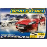 A collection of toys to include boxed Scalextric V12 Supercars set, Astin Martin red versus silver,