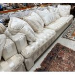 A pair of cream striped upholstered sofas of large proportions, each with five cushions,