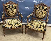 A pair of early 20th Century carved and stained walnut framed open arm chairs in the Louis XVI