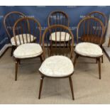 An Ercol elm rounded rectangular dining table on trestle end supports united by a centre stretcher