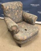 A late Victorian upholstered scroll armchair on turned and ringed front legs 85 cm wide x 80 cm