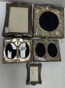 A collection of silver photograph frames to include a pair of twin frames with embossed floral swag