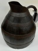 A mid 19th Century coopered oak ale jug of large proportions with iron banding and iron bound