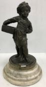 A Dutch bronze statue of a barefoot child in cap carrying basket sat on a stepped marble pedestal