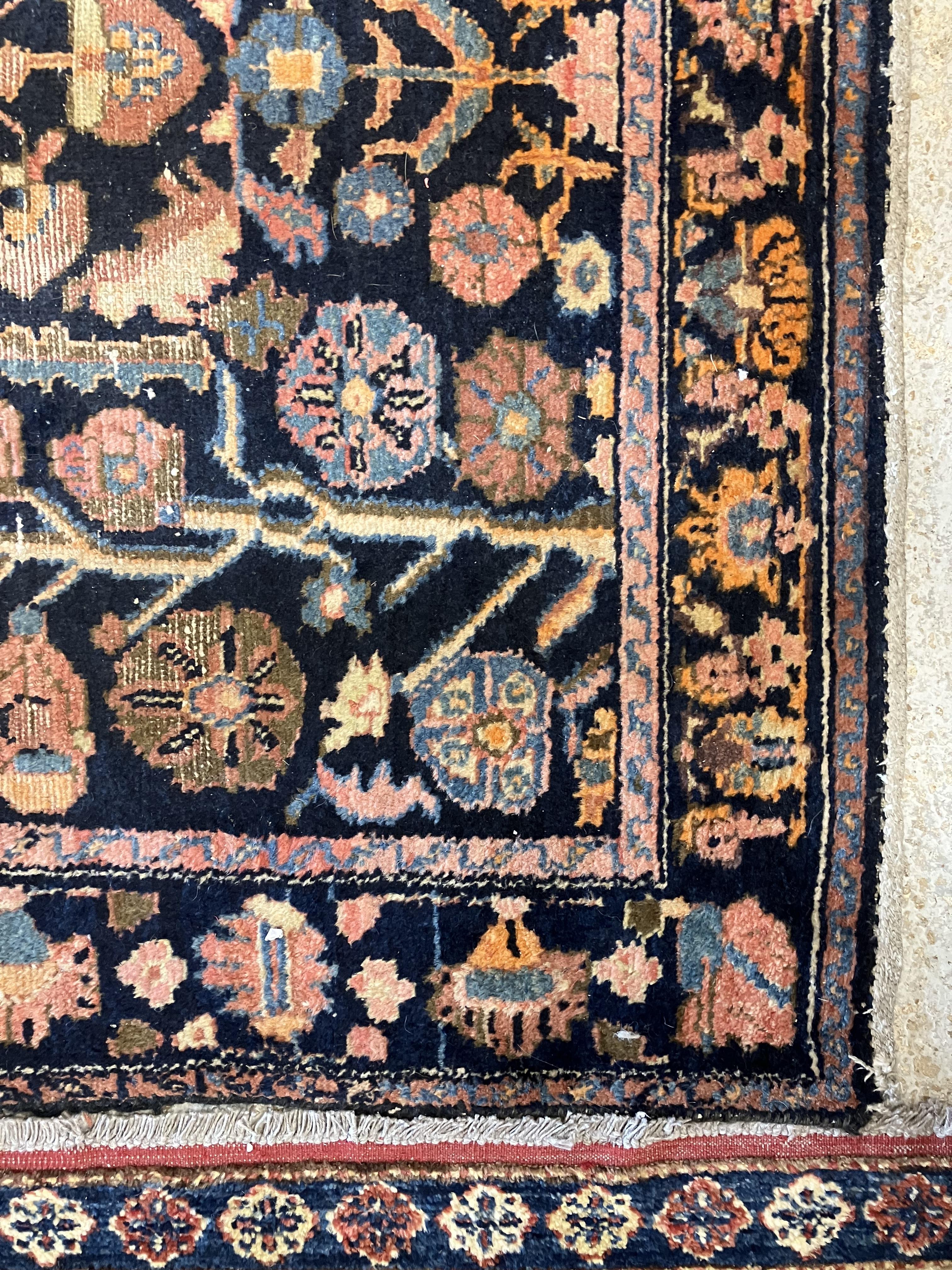 A Persian rug, the central panel set with all-over floral motifs on a dark blue ground, - Image 25 of 66