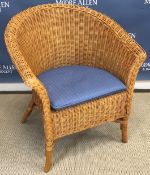 A wicker tub chair and an upholstered tea chest, the upholstery with carp type decoration,