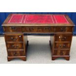 A modern yew wood double pedestal desk with tooled and gilded leather insert top over three frieze