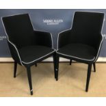 A pair of Coach House Alicia Grand black upholstered dining chairs with white leather piping on