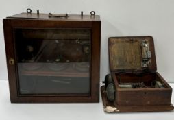 A mahogany cased therapy unit with three adjustable dials, two brass switches and two brass handles,