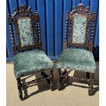A pair of Victorian carved oak Carolean style hall chairs with twin lion carved top rail over an