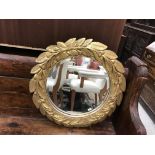A modern circular wall mirror in the 19th Century manner with leaf and fruit decorated frame and