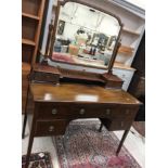 An Edwardian mahogany and inlaid mirror backed dressing table with central drawer flanked by two