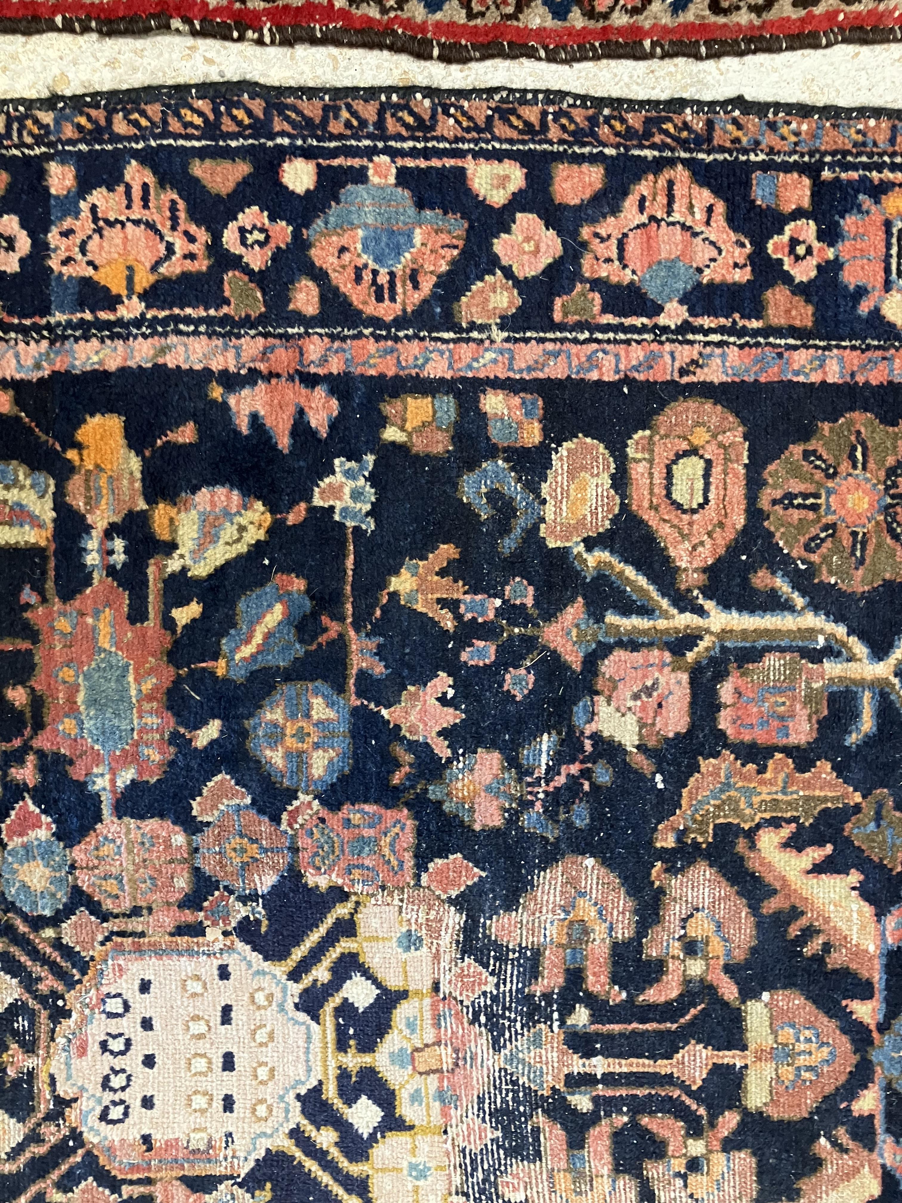 A Persian rug, the central panel set with all-over floral motifs on a dark blue ground, - Image 23 of 66