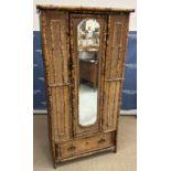 A Victorian "tortoiseshell" bamboo and raffia panelled single mirror door wardrobe with single