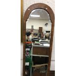 A 20th Century walnut veneered dome top wall mirror with bevel edged plate in the early 18th