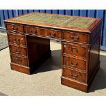 A modern yew wood double pedestal desk with tooled and gilded leather insert top over three frieze