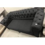 A charcoal grey buttoned upholstered drop arm Chesterfield sofa on turned bun feet to castors 205