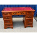 A modern yew wood double pedestal desk with tooled and gilded leather insert top over three frieze