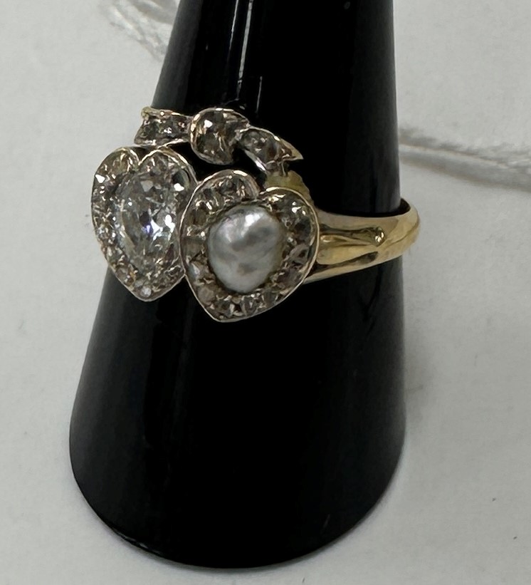 An 18 carat gold double loveheart design ring, one heart set with pear-shaped diamond, approx 0.