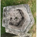 A weathered reconstituted stone pentagonal figural decorated planter, 46 cm diameter x 27 cm high,