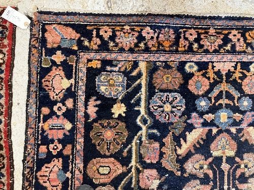 A Persian rug, the central panel set with all-over floral motifs on a dark blue ground, - Image 65 of 66