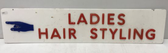 A mid 20th Century PVC sign with figure pointing left inscribed "Ladies Hair Styling" 66 cm x 14.