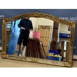 A modern gilt and mirrored framed mirror with serpentine top over a plain plate,