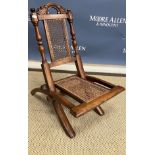 A Victorian child's walnut framed and caned campaign chair, 34.5 cm wide x 56.5 cm deep x 59.