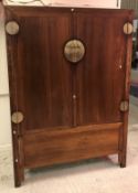 A Chinese Qing dynasty, hard wood (Poss. Huanghuali or Nanmu) two door cupboard or wardrobe of plain