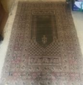A Ghiordes prayer rug, the central panel set with mihrab design with green ground within a stepped