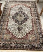 An Oriental carpet, the central panel set with floral decorated medallion on a blue and cream