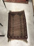 A Turkoman prayer rug, the central panel set on a cream and brown ground with geometric design