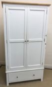 A modern white wood wardrobe with two cupboard doors over a single drawer, 100 cm wide x 57 cm