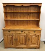 A 20th Century pine dresser, the two tier boarded plate rack over three drawers and three fielded