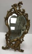 A brass easel mirror of shaped form in t