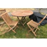 A modern teak circular folding garden ta