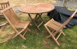 A modern teak circular folding garden ta