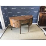 An Edwardian mahogany and inlaid sideboard of demi-lune form, the plain top over a central drawer,