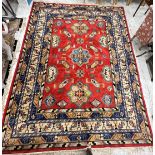 An Art Deco Chinese carpet, the central panel set with repeating geometric motifs on a red ground,